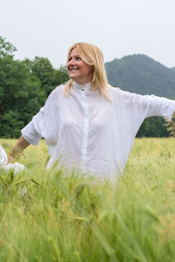 image of a woman smiling while walking through a field