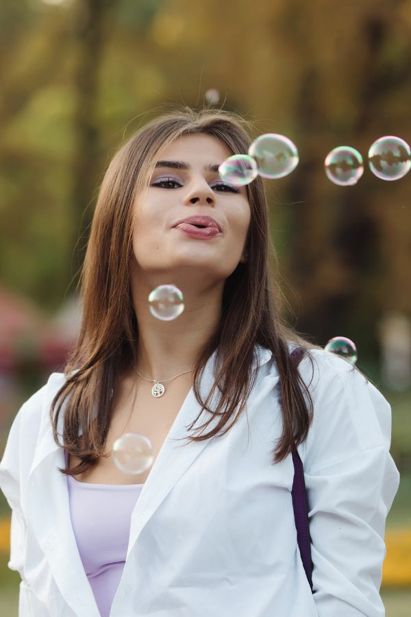 image of a woman blowing bubbles in a park